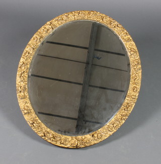 An oval bevelled plate wall mirror contained in a decorative gilt plaster frame with floral decoration 28 1/2" x 24" 