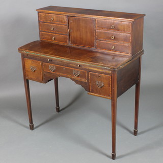 An Edwardian mahogany bonheur du jour, the raised back fitted a cupboard flanked by 6 short drawers with flip-over writing surface, the base fitted 1 long drawer flanked by 2 short drawers raised on square tapering supports ending in spade feet 