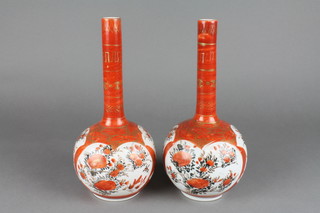 A pair of late 19th Century Kutani bottle vases with narrow necks decorated with panels of flowers 10"