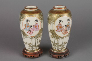 A pair of late 19th Century Satsuma over form vases, the bamboo decoration with panels of seated figures, seal mark to base 5"