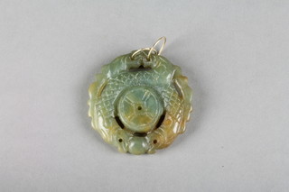 A carved and pierced jade pendant in the form of a dragon