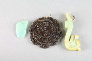 A carved hardstone belt clasp, a ditto circular pendant and fruit shaped pendant