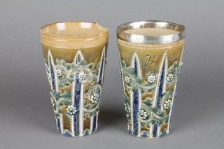 A pair of George Tinworth Doulton stoneware beakers, the base impressed 1873 5", 1 with silver mount and 1 with chip to rim and cracked