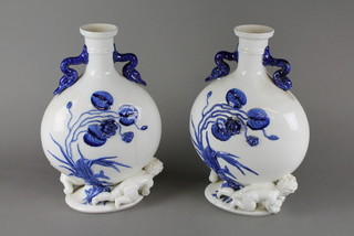 A pair of porcelain twin handled moon shaped vases decorated cherubs (cracked) 11" 