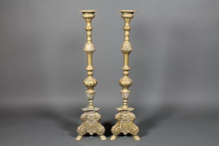 A pair of French Gothic style brass candlesticks raised on hoof feet, 41"h 