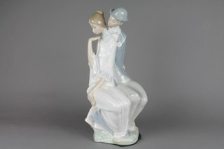 A Nao figure group of a courting couple seated on a rocky outcrop 16"