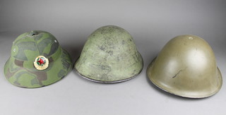 A Chinese fiberglass helmet, a Continental steel helmet the liner marked 1945 and 1 other steel helmet 