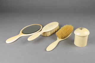An ivory backed 3 piece dressing table set comprising hand mirror and pair of hair brushes, together with a cylindrical dressing table jar 