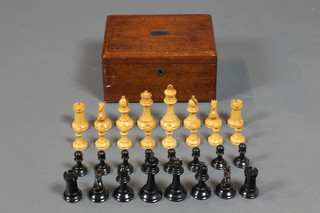 A Victorian ebony and boxwood turned Staunton pattern chess set contained in a mahogany box with hinged lid 
