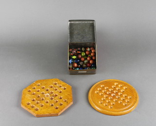 A circular wooden solitaire board, an octagonal ditto and a collection of various marbles