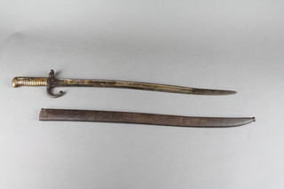 A French chassepot bayonet, the blade engraved and complete with metal scabbard (corroded and spring to grip f) 