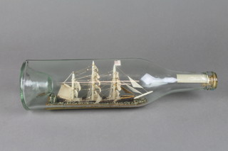 A model of a 3 masted ship in bottle marked Underweigh 12"