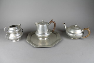 An English planished pewter 4 piece tea service comprising teapot, hotwater jug, twin handled sugar bowl and cream jug, the base marked W & C English Pewter and an octagonal Roundhead English pewter tray 11"