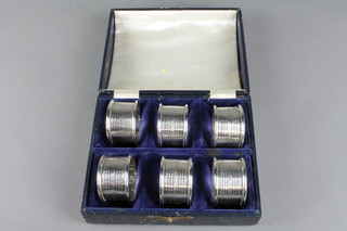 A set of 6 cased engine turned napkin rings engraved with the monogramme H, Birmingham 1924 3 ozs