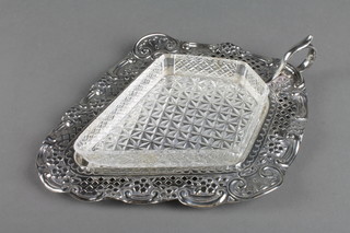 A Victorian silver butter dish stand of diamond form with pierced and repousse decoration and scroll handle and moulded glass liner, Sheffield 1898, 4.25 ozs