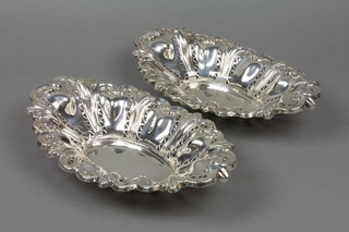A matched pair of pierced silver bon bon dishes with scroll decoration, approx 21 ozs, 12"