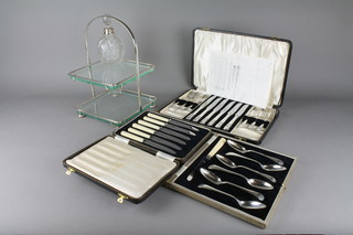 A cased set of Art Deco butter knives, 2 other cases sets and a mounted toilet bottle, together with a 2 tier cake stand
