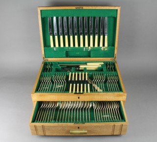 An Art Deco oak canteen containing a plated service of cutlery