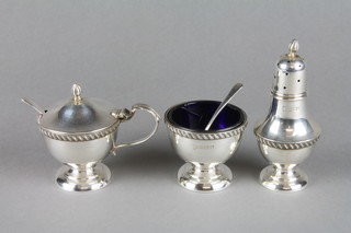 A silver 3 piece condiment set with gadroon rims and blue glass liners, Birmingham 1982 