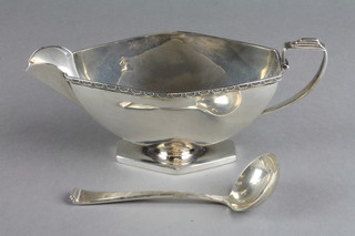 An Art Deco silver sauce boat with fancy rim and D scroll handle with similar spoon, Birmingham 1936, approx. 6 ozs 