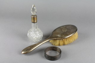 A silver backed hairbrush, a ditto bangle and a silver mounted dressing table bottle 