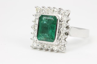 An 18ct white gold emerald and diamond ring, the emerald cut centre stone approx 4.05ct surrounded by 22 brilliant cut diamonds, approx. 0.75ct 