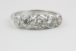 An 18ct white gold graduated 5 stone diamond ring in rub over setting, approx 1.55ct 