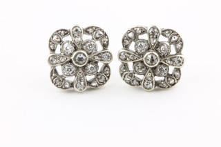 A pair of Edwardian white gold open floral style ear studs, set with brilliant cut diamonds