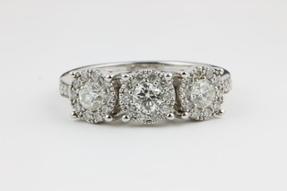 An 18ct white gold diamond ring with 3 brilliants surrounded by smaller brilliants in a claw set mount, approx. 1.02ct