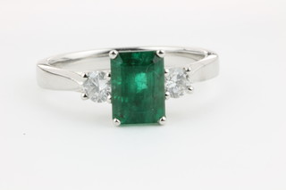 An 18ct white gold emerald and diamond ring, the centre rectangular cut emerald approx 1.63ct flanked by brilliant cut diamonds approx. 0.27ct