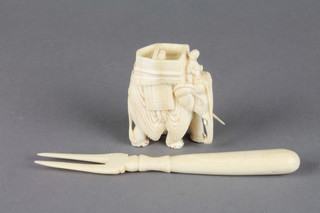 A carved ivory figure of an elephant 2 1/2" and a fork
