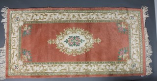 A pink ground and floral patterned Indian rug 73" x 36" 