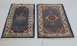 A pair of Indian blue ground rugs with central medallion 55" x 26" and 56" x 28" 