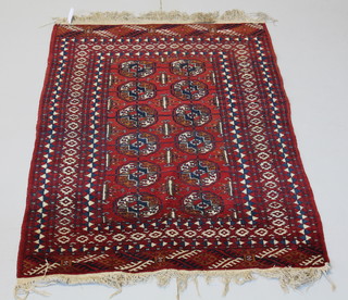 A red ground Bokhara rug with 12 octagons to the centre 65" x 39" 