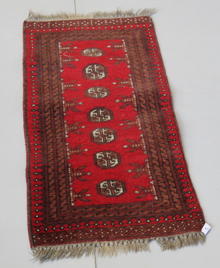 A red ground Afghan runner with 7 octagons to the centre 52" x 19 1/2" 