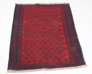 A Persian Balochi red and blue ground rug with all-over geometric design 57" x 33" 