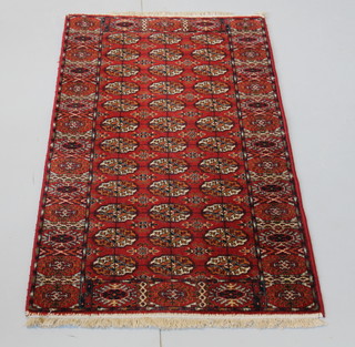 A pair of machine made Bokhara style rugs with 36 octagons to the centre 64" x 29" 