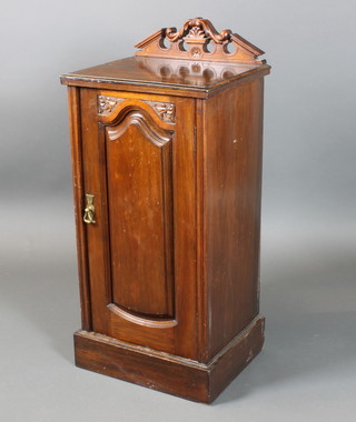A Victorian carved walnut pot cupboard with raised back, enclosed by a panelled door on a platform base 35"h x 15 1/2"w x 13"d 