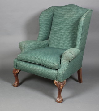 A Georgian style winged armchair upholstered in green material 