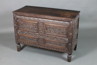 A heavily carved oak coffer raised on turned cup and cover feet with hinged lid, constructed from old timber, 31"h x 43"w x 18 1/2"d