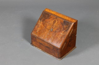 A Victorian figured walnut stationery box of wedge form enclosed by panelled doors revealing a stepped and fitted interior, having a perpetual calendar to the back and secret drawer 14"h x 16"w x 11 1/2"d