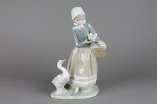 A Lladro figure of a goose girl carrying a basket of goslings no.4568 10"