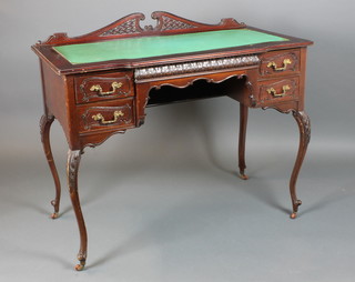 A Victorian mahogany writing table inset a green writing surface, the raised carved back with broken cornice above 4 long drawers, raised on cabriole supports 33"h x 38 1/2"w x 20"w