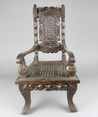 A childs Carolean style open arm chair with woven cane seat and back and pierced carved decoration, raised on cabriole supports 19"h x 11 1/2"w x 11 1/2"d