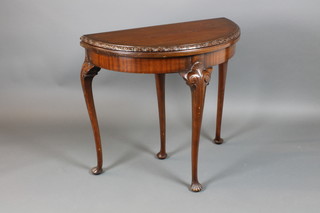 A 1930's Georgian style mahogany demi-lune card table, raised on cabriole supports 29"h x 31 1/2"w x 15 1/2"d