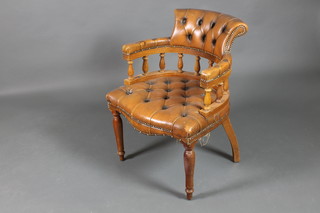 A mahogany framed tub back office chair upholstered in brown buttoned leather 