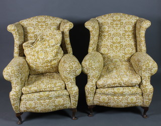 A pair of Georgian style winged armchairs upholstered in yellow material, raised on cabriole supports