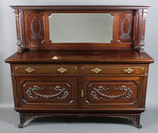 An Edwardian carved mahogany sideboard, the raised mirrored back with moulded and dentil cornice supported by 2 square columns, the base fitted 2 long drawers with brass ring drop handles above a cupboard fitted shelves enclosed by panelled doors with swag decoration, raised on scrolled feet 65"h x 72w x 25"d 