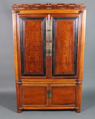 A Chinese hardwood cabinet on cabinet inlaid ivory, the interior fitted shelves enclosed by panelled doors 70 1/2"h x 43"w x 23"d 