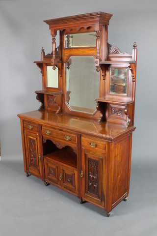 A late Victorian walnut chiffonier sideboard with raised mirrored back fitted 4 bevelled plate mirrors, the base fitted 1 long drawer above a recess and cupboard flanked by 2 short drawers above cupboards enclosed by carved panelled doors, raised on turned supports 86"h x 59"w x 19"d 